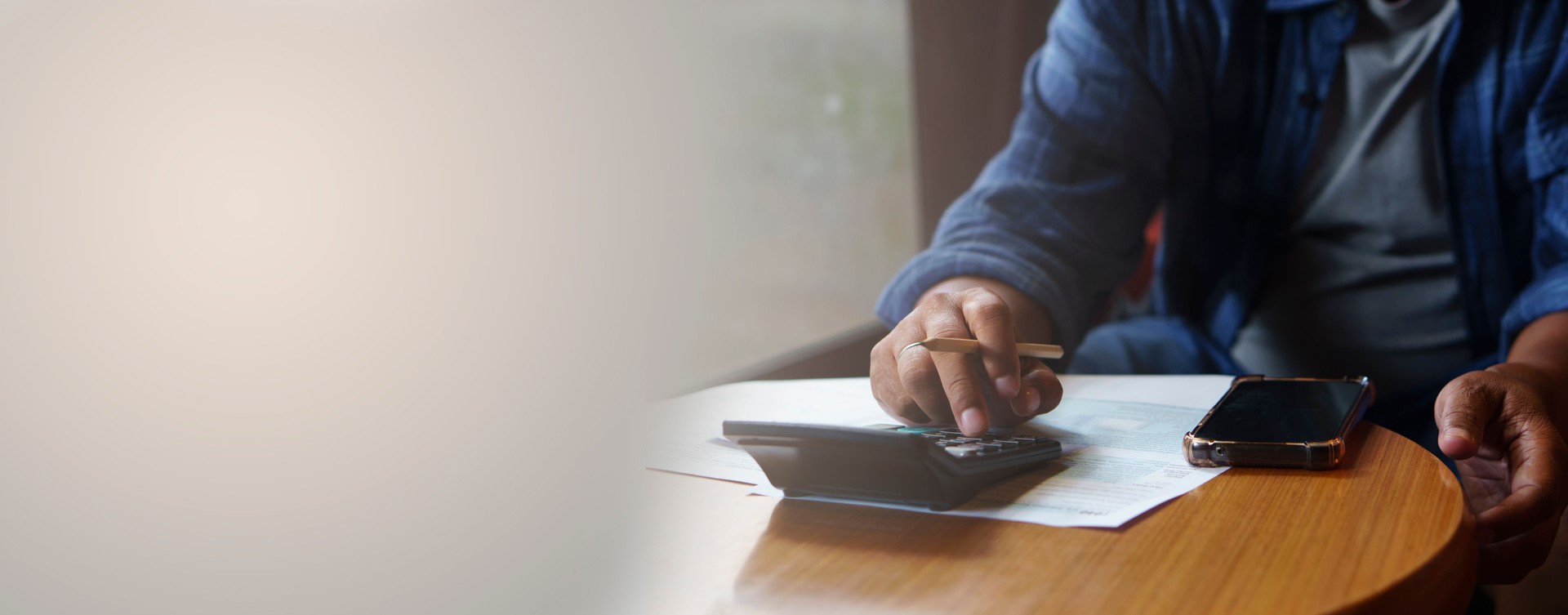 Business man use calculator, smartphone, and review tax form at home office. Financial advisor hand plan and calculate budget. Business and Financial Planning Concept-banner image.