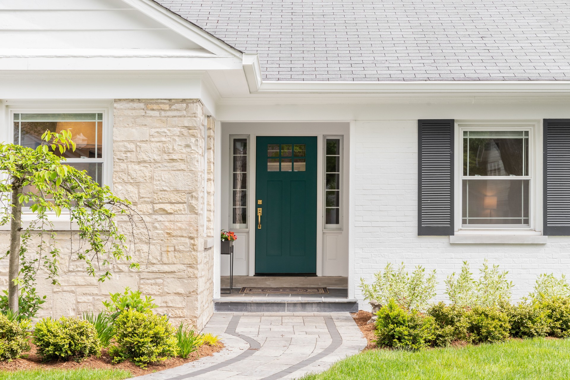 A green front door detail on a white home.
